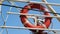 Red lifebuoy attached to a ship railing