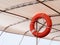 Red lifebuoy, life preserver hanging on roof of boat for fast safety rescue boat. Life Buoy on a Cruise Ship