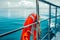 Red lifebuoy on ship railing with sea surface