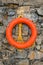 Red lifebuoy on a stone wall. The concept of safety on the waters, first aid for drowning people