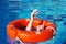 Red lifebuoy on the surface of the water in the pool and the hands of a man grabbing it