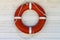 Red lifebuoy on the white wood painted wall background