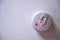 Red light batter indicator on a smoke detector mounted on a ceiling