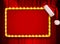 Red light sign with gold frame and Christmas hat on red theatre or cinema curtain. Mixed media.