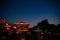 Red light up on the Chinese temple under the crescent moon.