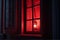 red light from the window. the red window shines mystically at night. mysterious red window