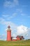 Red Lighthouse Bovbjerg Fyr with green grass and blue sky