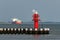 Red lighthouse with cargo ship in background, Brunsbuettel, Schleswig-Holstein, North Sea, Germany