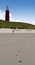 Red lighthouse with footsteps on the beach