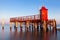 Red lighthouse on the sea in Lignano Sabbiadoro. Punta Faro Beach.