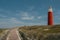 Red lighthouse on texel island wooden railing near footpath