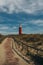 Red lighthouse on texel island wooden railing near footpath