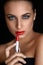 Red lips. Beutifull Woman Doing Makeup Applying lipstick