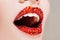 Red lips covered with rhinestones. Beautiful woman with red lipstick on her lips.