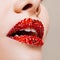 Red lips covered with rhinestones. Beautiful woman with red lipstick on her lips.