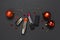 Red lipstick, Christmas balls, confetti on black background top view flat lay copy space. Professional Makeup and Beauty.