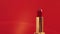 Red lipstick in golden tube and shining light flares, luxury make-up product and holiday cosmetics for beauty brand