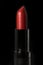 Red lipstick isolated on black background