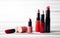 red lipstick, lip gloss, mascara, powder on white wooden table soft light for beauty fashion design