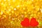 Red little decorative hearts against gold yellow sparkle glitter background with amazing bokeh lights. Love or romantic Valentine