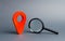 Red location pointer and a Magnifying glass on a gray background. Concept of navigation and venue. Tourism and travel. Spying