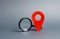 Red location pointer and a Magnifying glass on a gray background. Tourism and travel. Spying on the citizens.. Orientation around