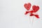 Red lollipops hearts with silk bow on white wood board as festive valentines day background.