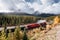 Red long freight train on railway passing through autumn valley with mountain at Morant\\\'s Curve