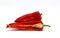 Red long ripe sweet pepper and its half on a light background.