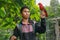 Red loryperching on the man hand. Asian handsome tenager with a parrot in a tropical bird park. Eos Bornea is a species