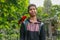 Red loryperching on the man hand. Asian handsome tenager with a parrot in a tropical bird park. Eos Bornea is a species