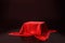 Red luxurious fabric placed on top pedestal or blank podium shelf on black background with luxury concept. 3D rendering