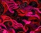 Red and magenta waves create a pattern on a dark background. Acrylic or watercolor grunge texture.