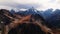 Red majestic rocks dusted with snow high in the mountains. Flying near high peaks and mountain tops at sunset. Aerial