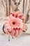 Red manicure and gentle gerbera.