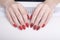 Red manicure with a pattern. Female hands in manicure salon