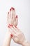 Red manicure with a pattern. Female hands on a white background