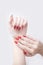 Red manicure with a pattern. Female hands on a white background