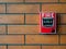 Red manual pull fire alarm safety system. Pull station or call point, manual fire alarm activation on brick wall background