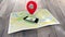 red marker pointing at a mobile lying on a map of a town