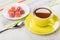 Red marmalade in saucer on napkin, teaspoon, cup of tea