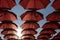 Red marsala umbrellas against the blue sky and sun. View from below. Abstract background with red umbrellas. Seamless pattern wit