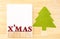 Red x\'mas word and blank postcard with green christmas tree in w