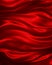 Red material background with draped folds and wrinkles with silk texture