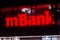 Red mBank sign in the office at night. mBank is Poland`s fourth largest universal banking group.