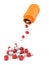 Red medicine pills falling from a orange bottle