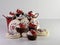 Red metal basket full of cupcakes with red and white cream and vanilla iced sugar cookies