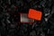 Red metal box on charcoal back. Copy space in a rectangle on a background of hot coals