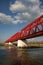 Red metal crossing bridge used by trains to go across a big river