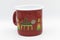 Red metal cup with painted cats on the side.